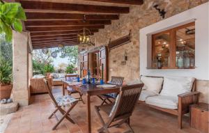 una sala de estar al aire libre con mesa de madera y sillas. en Beautiful Home In Alar With Private Swimming Pool, Can Be Inside Or Outside, en Alaró