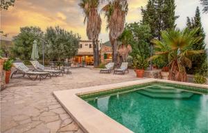 una piscina en un patio con sillas y mesa en Beautiful Home In Alar With Private Swimming Pool, Can Be Inside Or Outside, en Alaró