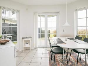 ボーゲンセにある4 person holiday home in Bogenseのキッチン、ダイニングルーム(白いテーブル、椅子付)