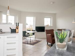 a kitchen and living room with a table with a plant in a vase at 4 person holiday home in Bogense in Bogense