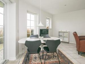 a dining room with a white table and chairs at 4 person holiday home in Bogense in Bogense