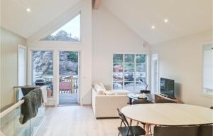 un soggiorno con tavolo e TV di 3 Bedroom Amazing Home In Tvedestrand a Tvedestrand