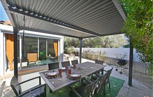 a patio with a table and chairs under awning at Beautiful Home In La Grande-motte With Kitchen in La Grande-Motte