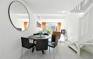 a dining room with a table and chairs and a mirror at Beautiful Home In La Grande-motte With Kitchen in La Grande-Motte
