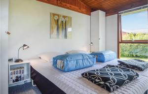 een slaapkamer met een bed met blauwe zakken erop bij Beautiful Home In Hejls With House Sea View in Hejls