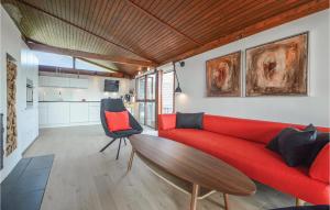 een woonkamer met een rode bank en een tafel bij Beautiful Home In Hejls With House Sea View in Hejls