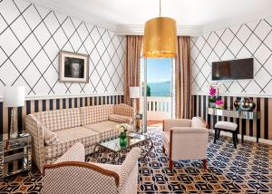 un soggiorno con divano e sedie di Hôtel Belles Rives a Juan-les-Pins