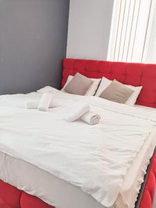 1 cama blanca grande con cabecero rojo en Boutique Apartment, en Plovdiv