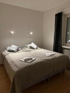 a bedroom with a bed with two towels on it at Lapinmaa Apartments in Rovaniemi