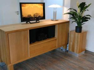 a wooden entertainment center with a television on top of it at Ohlerich Speicher App_ 42 in Wismar