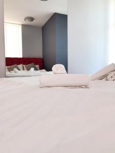 Una cama blanca con dos toallas encima. en Boutique Apartment, en Plovdiv