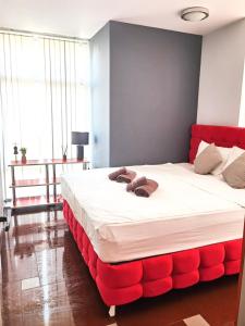 1 dormitorio con 1 cama grande con acolchado rojo en Boutique Apartment, en Plovdiv