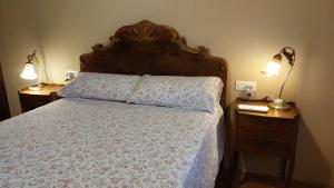 a bedroom with a bed and two night stands with lamps at La Calma Montblanc Prenafeta in Prenafeta