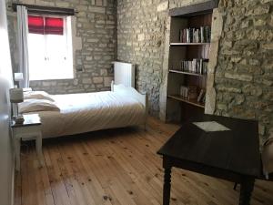 een slaapkamer met een bed en een boekenplank bij Gites de Jeand'Heurs in Lisle-en-Rigault