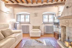 uma sala de estar com um sofá e uma lareira em Casa Samuela - Together in Tuscany em Cortona