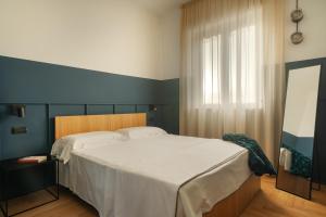 Un dormitorio con una cama grande y una ventana en Re Versiliana Hotel, en Marina di Pietrasanta