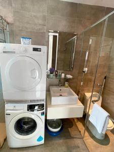 a bathroom with a washing machine and a sink at H2O Residences Ara Damansara PJ with WiFi Washing Machine and Dryer in Petaling Jaya