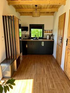 a kitchen with a wooden floor and a counter top at sKLONowane domki pod Czarną Górą in Bystrzyca Kłodzka