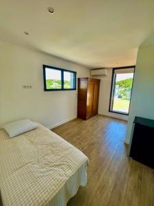 ein Schlafzimmer mit einem Bett und zwei Fenstern in der Unterkunft Villa de vacances sur la Côte bleue à la couronne in Martigues