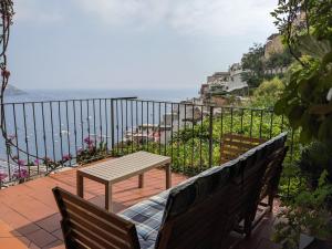 a table and two benches on a balcony overlooking the ocean at Casa Giovanna Positano in Positano