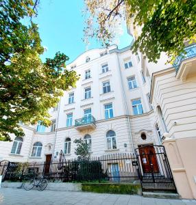 a white building with a fence in front of it at Krakowskim Szlakiem - OLD TOWN in Krakow