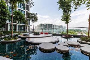 a building with a pool of water with trees and buildings at H2O Residences Ara Damansara PJ with WiFi Washing Machine and Dryer in Petaling Jaya