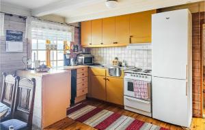 cocina con armarios amarillos y nevera blanca en Stunning Home In Mosvik With House Sea View, en Mosvik