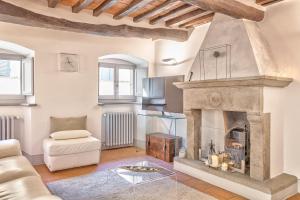 uma sala de estar com lareira e sofá em Casa Samuela - Together in Tuscany em Cortona