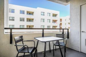 a table and chairs on a balcony with a building at Hollywood 2BR w Gym Pool Spa nr Sunset Blvd LAX-198 in Los Angeles