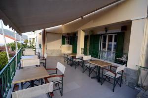 an outdoor patio with tables and chairs on a balcony at Stella Hotel Apartments in Fiskardo