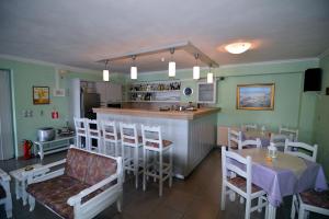 a dining room with a bar and a table and chairs at Stella Hotel Apartments in Fiskardo