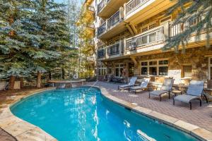 a swimming pool in front of a house with a building at Lone Eagle Ski In Ski Out Condo in Dillon