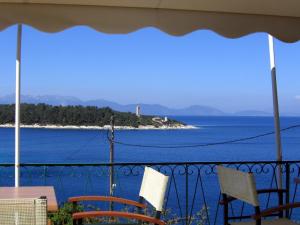 a balcony with chairs and a view of the ocean at Stella Hotel Apartments in Fiskardo