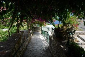 a walkway with flowers hanging from a fence at Stella Hotel Apartments in Fiskardo