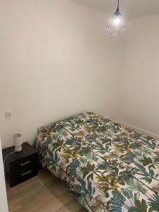 1 dormitorio con 1 cama, mesita de noche y lámpara en Hôtel Particulier Morez, en Morez