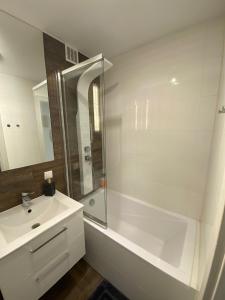 a white bathroom with a shower and a sink at Przy Moście in Rzeszów