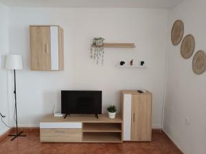 a living room with a tv on a wooden entertainment center at San Acacio 22 in Ronda