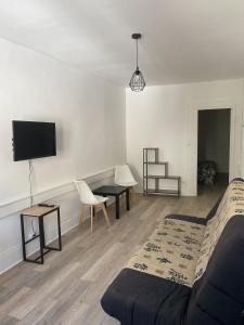1 dormitorio con 1 cama, escritorio y TV en Hôtel Particulier Morez en Morez