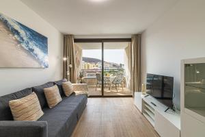 a living room with a couch and a television at Valdes Center Los Cristianos in Los Cristianos
