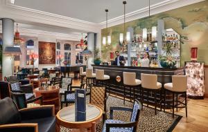 a restaurant with a bar and tables and chairs at Hôtel Belles Rives in Juan-les-Pins
