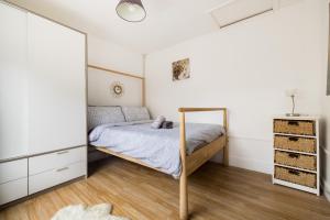 1 dormitorio con cama y espejo en 1BD Apartment near Olympic Park, East London en Londres