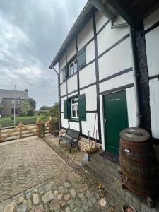 ReijmerstokにあるHet Houwershuuskeの緑の扉と樽を備えた白と緑の建物 +7枚の写真