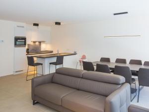 uma sala de estar com um sofá e uma mesa em Riva spacious and modern with top location em Middelkerke