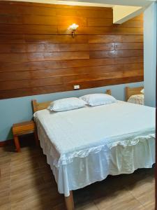 a bedroom with a bed with a wooden wall at Huan Kaw Fang in Mae On