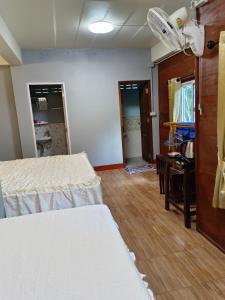 a room with two beds and a desk in it at Huan Kaw Fang in Mae On