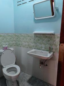 a bathroom with a toilet and a sink at Huan Kaw Fang in Mae On