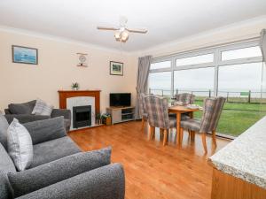 a living room with a couch and a table and chairs at Beach Croft in Lowestoft