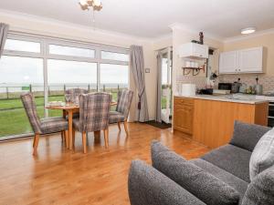 a kitchen and living room with a table and chairs at Beach Croft in Lowestoft