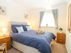 a bedroom with a bed with a teddy bear on it at Beach Croft in Lowestoft