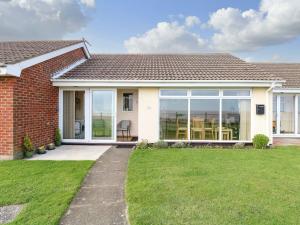 a house with large windows and a lawn at Beach Croft in Lowestoft